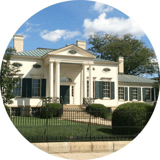 A white house with blue shutters and green shutters.