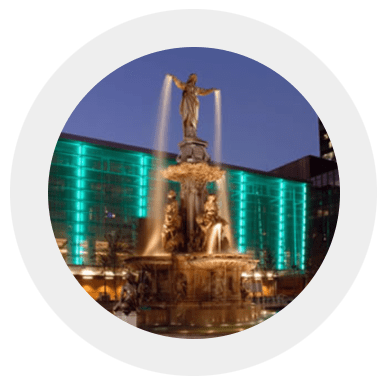 A picture of the fountain in front of a building.